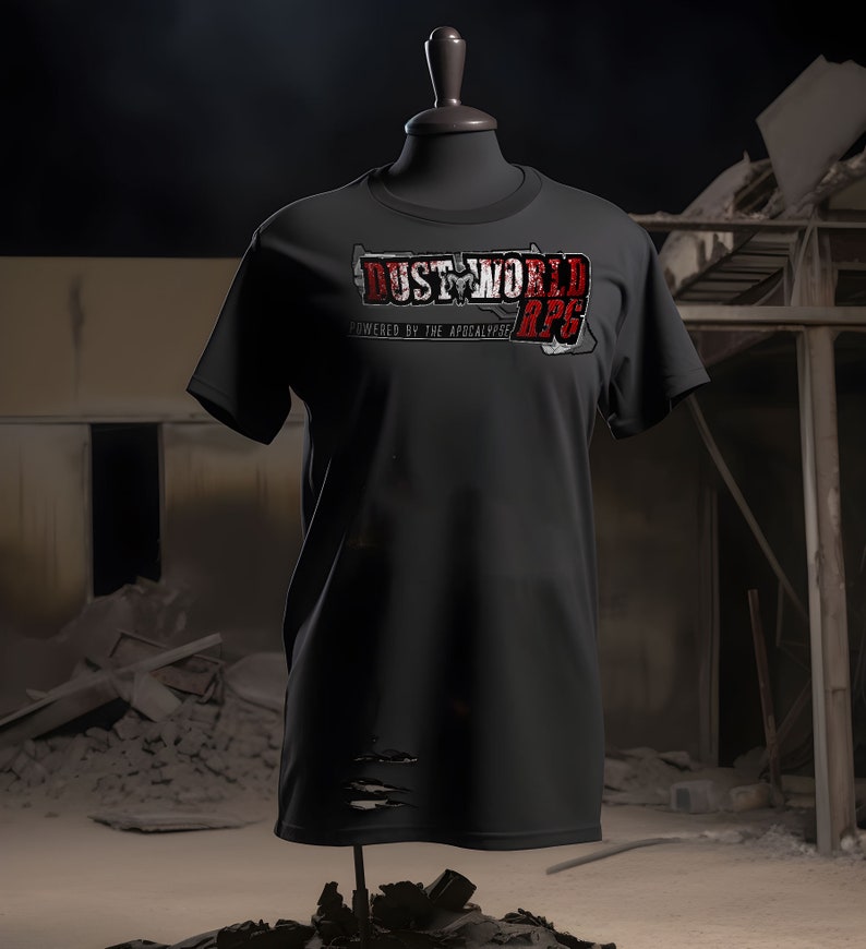 K&ouml;nnte beinhalten: Schwarzes T-Shirt mit einem abgenutzten roten und wei&szlig;en Grafik, auf dem "Dust World RPG Powered by the Apocalypse" steht.