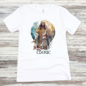 May include: White t-shirt with a graphic of Jesus holding a sword and the text "Jesus is my Cleric".