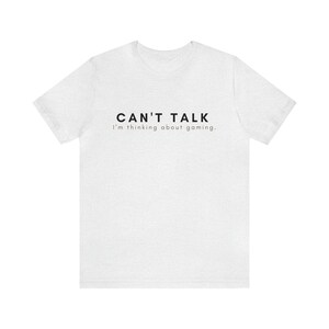 K&ouml;nnte beinhalten: Wei&szlig;es T-Shirt mit schwarzem Text, der "CAN'T TALK I'm thinking about gaming." lautet.