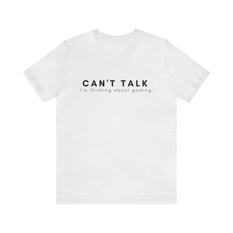 K&ouml;nnte beinhalten: Wei&szlig;es T-Shirt mit schwarzem Text, der "CAN'T TALK I'm thinking about gaming." lautet.