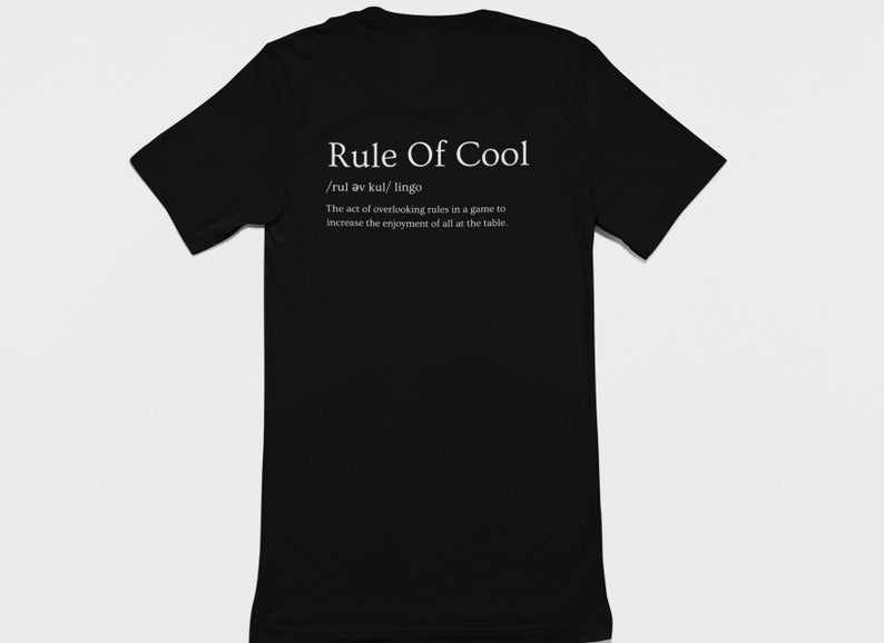 May include: Black t-shirt with white text that reads "Rule Of Cool /rul av kul/ lingo The act of overlooking rules in a game to increase the enjoyment of all at the table."