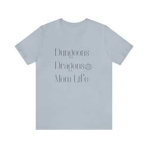 May include: Light blue t-shirt with the text "Dungeons & Dragons Mom Life" and a Dungeons & Dragons dice symbol.