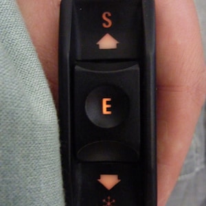 以下が含まれることがあります： オレンジ色の「S」と「E」の文字と、上向き矢印と下向き矢印が付いた黒い窓のスイッチです。