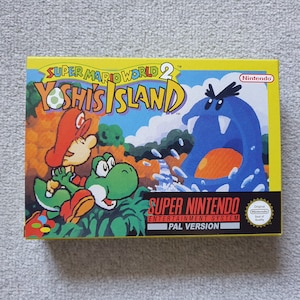 May include: A rectangular video game box for Super Mario World 2 Yoshi's Island. The cover features a colourful illustration of Mario riding a green Yoshi, facing a large blue creature. The text reads Super Mario World 2 Yoshi's Island, Super Nintendo Entertainment System, and PAL Version.