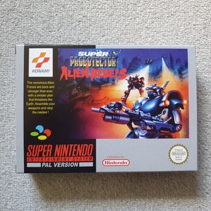 May include: Super Nintendo Entertainment System game cartridge box for Super Probotector: Alien Rebels. The box is grey with a colourful image of a robot fighting aliens. The text "Super Probotector: Alien Rebels" is printed in large, bold letters on the front of the box.