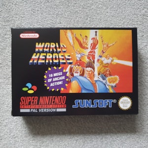 May include: A black Super Nintendo video game box for World Heroes. The front features the game title, a colourful illustration of various characters, and a purple starburst graphic with the text 16 MEGS OF ARCADE ACTION. Includes Nintendo branding.