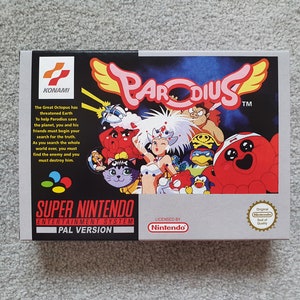 May include: A Super Nintendo Entertainment System game cartridge for Parodius, a shoot 'em up video game. The box art features a colourful illustration of characters from the game, including a red octopus, a cat, a woman with white hair, and a penguin. The text on the box reads "Parodius" and "Super Nintendo Entertainment System PAL Version".