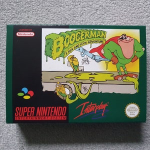 May include: Super Nintendo Entertainment System game cartridge box for Boogerman: A Pick and Flick Adventure. The box is green with a cartoon character on the front. The text "Boogerman: A Pick and Flick Adventure" is written in white letters on a green background.