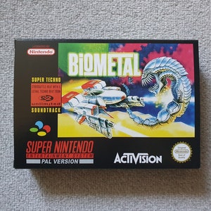 May include: A black Super Nintendo game cartridge box featuring a colourful image of a spaceship fighting a large, silver, alien-like creature. The game title is "Biometal" and the publisher is Activision. The box also includes the text "Super Techno" and "Unlimited Soundtrack".