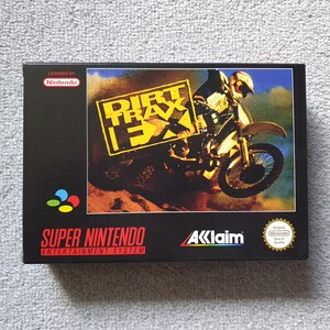 May include: A black Super Nintendo game box for "Dirt Trax FX." The box art shows a motocross racer on a yellow motorcycle, with the game's title in yellow and black. The box also displays the Nintendo and Acclaim logos.