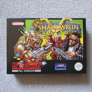 May include: A rectangular Super Nintendo Entertainment System game box for Shadowrun. The black box features a colourful illustration of a creature with a weapon, a horned skull, and a person with a keyboard. Includes Nintendo and Laser Beam logos.