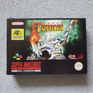 May include: Super Turrican video game cartridge for the Super Nintendo Entertainment System. The cartridge is black with a colourful image of a robot on the front. The text "SUPER TURRICAN" is printed in white on the front of the cartridge. The text "PAL VERSION" is printed in white on the front of the cartridge.