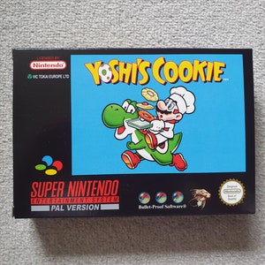 May include: A black Super Nintendo Entertainment System game cartridge box with a blue background. The box features a cartoon image of Yoshi carrying Mario, who is dressed as a chef, and holding a tray of cookies. The game title "Yoshi's Cookie" is printed in yellow letters on the box. The box also includes the text "Licensed by Nintendo" and "VIC TOKAI EUROPE LTD".