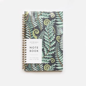 May include: A spiral bound notebook with a dark green and light green fern pattern on the cover. The cover also has a white label with the text "ROOT & BRANCH paper co. NOTE BOOK 120 lined pages made in the USA."