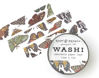 May include: A roll of washi tape with a butterfly design. The tape is white with brown, orange, and yellow butterflies. The tape is 15mm wide and 10m long. The label on the tape reads "Root & Branch paper co. Washi removable paper tape 15mm x 10m".
