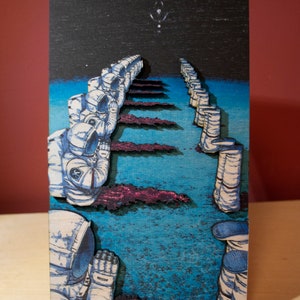 May include: A wooden art piece depicting a line of astronauts in white space suits, walking towards a bright light in the night sky. The artwork features a blue and purple color scheme, with a wooden stand.