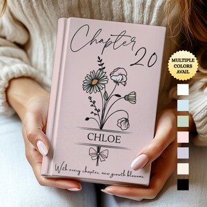 May include: A pink journal with the text "Chapter 20" and the name "Chloe" in script. The cover features a floral design and the phrase "With every chapter, new growth blossoms." A sticker indicates multiple colors are available.