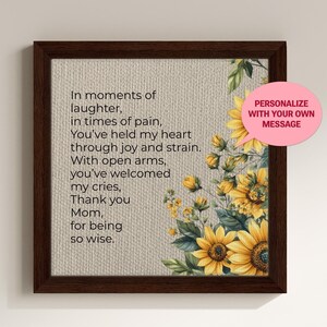 May include: A framed print with a beige background and a poem about a mother. The poem reads: "In moments of laughter, in times of pain, You've held my heart through joy and strain. With open arms, you've welcomed my cries, Thank you Mom, for being so wise." The print is decorated with a floral design featuring sunflowers.