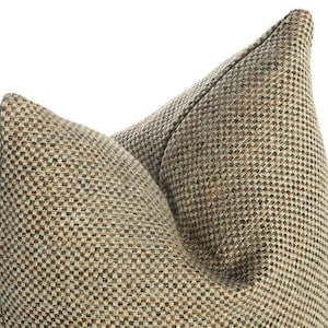 May include: A close-up of a brown and beige patterned pillow with a square weave texture.
