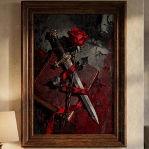 Puede incluir: Una obra de arte enmarcada que presenta una rosa roja, una daga y un libro. La rosa se coloca encima de la daga, con una cinta roja que los envuelve. El fondo es una mezcla de tonos rojo oscuro y gris, creando un efecto dram&aacute;tico. El marco es de madera marr&oacute;n.