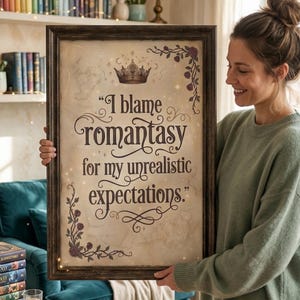 May include: A framed print with the text "I blame Romantasy for my unrealistic expectations." The print has a vintage parchment background, a gold crown, and floral accents. The frame is dark brown.