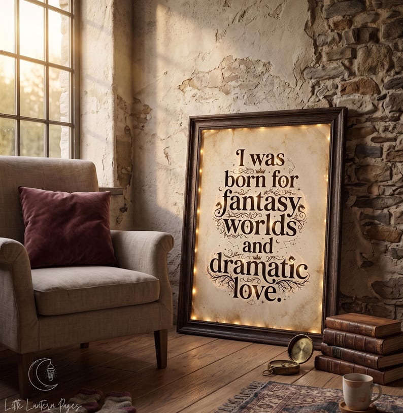 May include: A rectangular framed sign with a dark wood border and internal warm string lights. The off-white parchment-style background features the dark brown text: I was born for fantasy worlds and dramatic love, decorated with small crowns and stars.