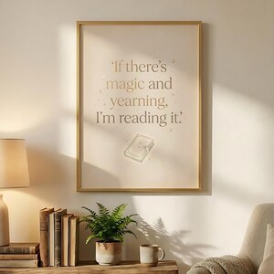 May include: A framed print with the quote, "If there's magic and yearning, I'm reading it." The text is in a gold color, with a small book illustration. The frame is gold, and the background is a light beige.