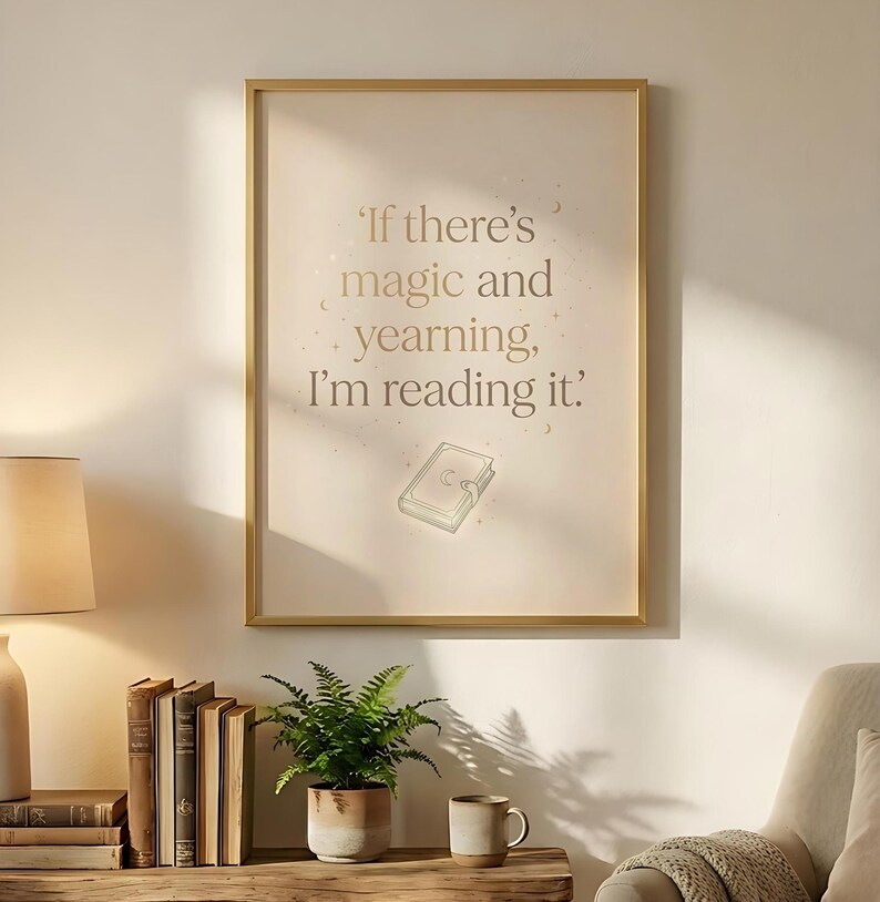 May include: A framed print with the quote, "If there's magic and yearning, I'm reading it." The text is in a gold color, with a small book illustration. The frame is gold, and the background is a light beige.