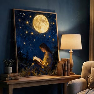 May include: A framed art print showing a woman reading beneath a full moon and a starry night sky. The artwork uses a warm colour palette, highlighting the moon and the book the figure is reading. The print is displayed on a wooden table.