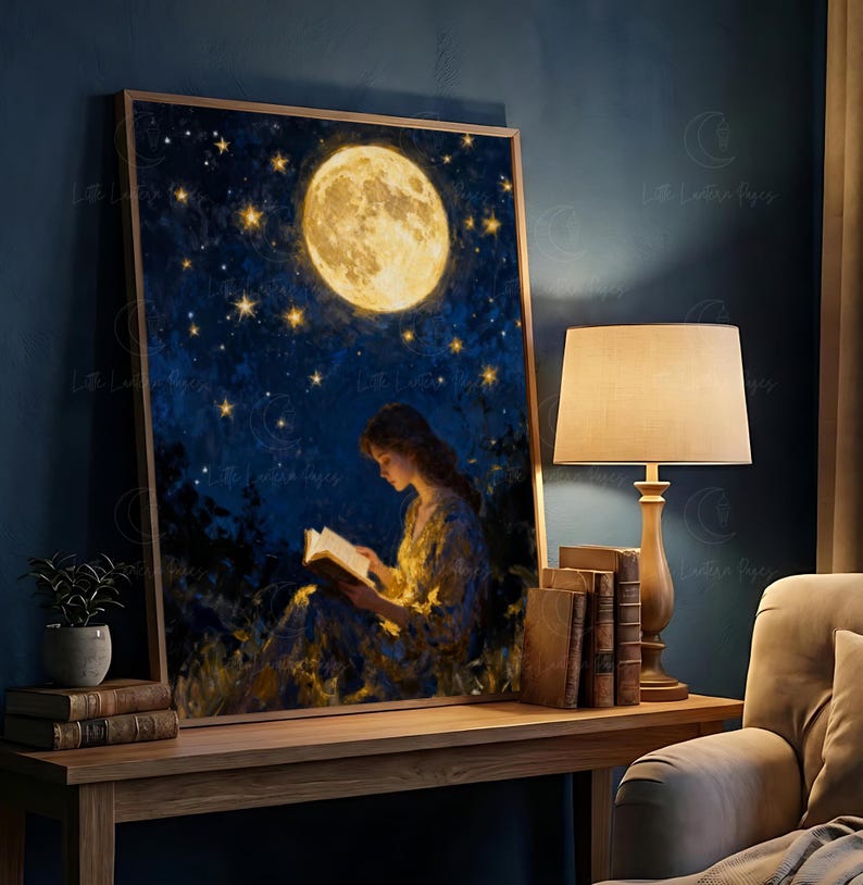 May include: A framed art print showing a woman reading beneath a full moon and a starry night sky. The artwork uses a warm colour palette, highlighting the moon and the book the figure is reading. The print is displayed on a wooden table.
