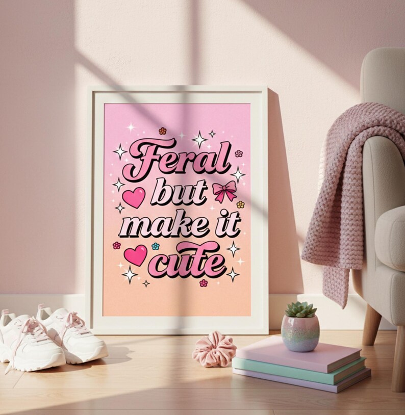 Puede incluir: Una impresi&oacute;n art&iacute;stica enmarcada con el texto "Feral but make it cute" en una fuente retro. La impresi&oacute;n tiene un fondo degradado rosa y melocot&oacute;n con corazones, estrellas y flores. La obra de arte se exhibe cerca de zapatillas blancas.