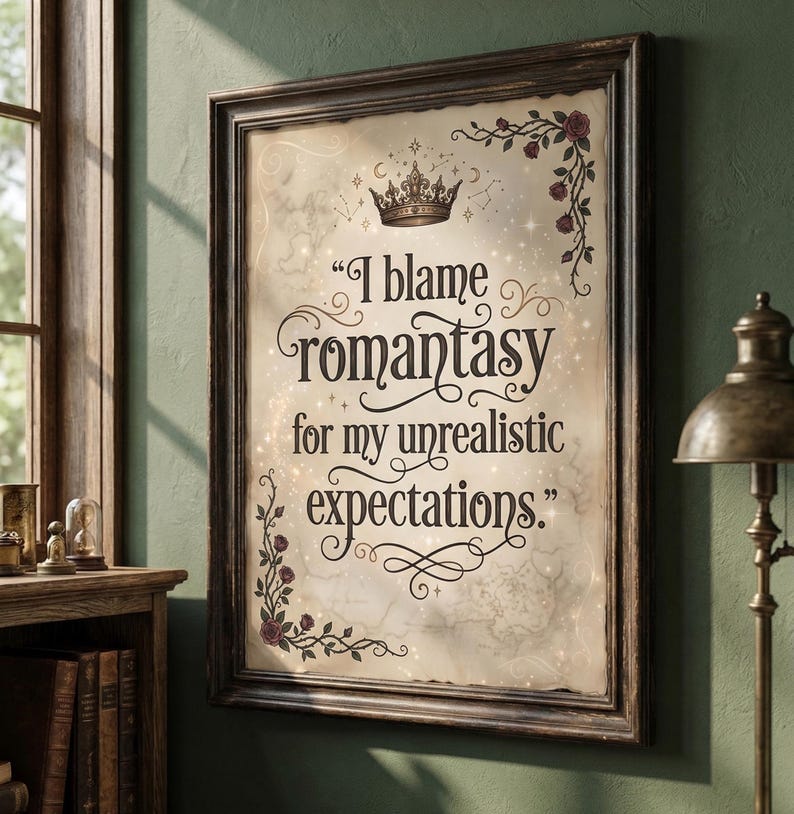 May include: A framed print displaying the quote "I blame romantasy for my unrealistic expectations." The design includes a vintage map backdrop, a gold crown, and floral embellishments. The frame is dark brown.