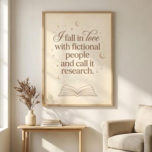 Pu&ograve; includere: Una stampa incorniciata con la citazione "Mi innamoro di persone immaginarie e la chiamo ricerca". L'opera presenta uno sfondo beige chiaro con testo marrone, costellazioni e un'illustrazione di un libro aperto. La cornice &egrave; color legno chiaro.