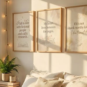 Pu&ograve; includere: Tre stampe artistiche incorniciate con citazioni ispiratrici sui libri e la lettura. Le stampe hanno uno sfondo beige chiaro con testo e illustrazioni di libri aperti. La prima stampa recita: "Mi innamoro di persone immaginarie e la chiamo ricerca."