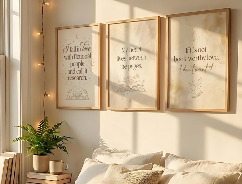 Pu&ograve; includere: Tre stampe artistiche incorniciate con citazioni ispiratrici sui libri e la lettura. Le stampe hanno uno sfondo beige chiaro con testo e illustrazioni di libri aperti. La prima stampa recita: "Mi innamoro di persone immaginarie e la chiamo ricerca."