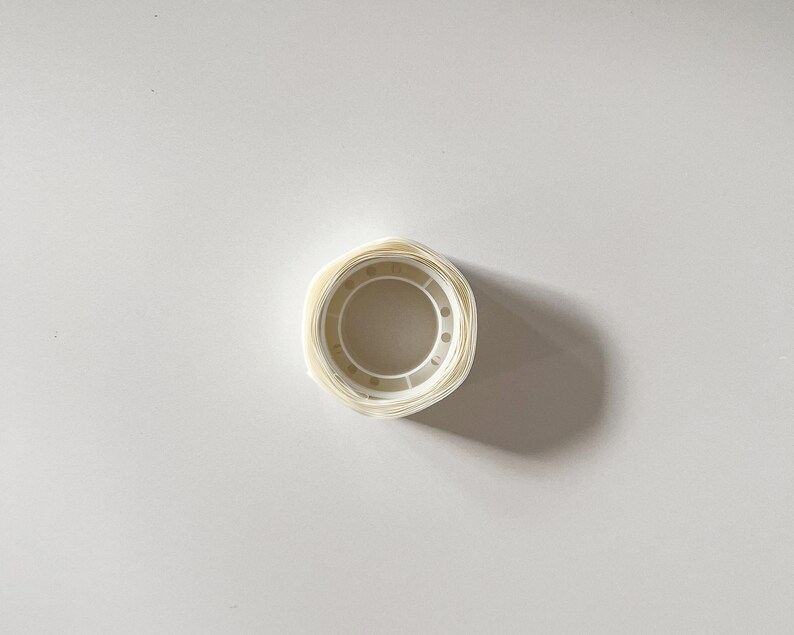 Top view of a single roll of transparent glue dots. Glue stickers are great for craft projects and tacking down dollhouse miniatures to keep them in place.