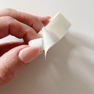 Detail of glue dot on bottom of miniature mug. Glue stickers are double-sided,  temporary hold and do not leave a residue when removed.