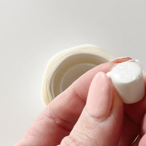 Detail of glue dot on bottom of miniature mug. Glue stickers are temporary hold and do not leave a residue when removed.