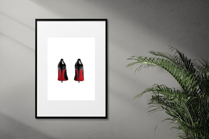May include: A framed print of two black high-heeled shoes with red soles, viewed from the back.
