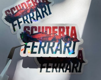 May include: Two Scuderia Ferrari stickers with a red and black color scheme. The stickers feature a Formula One race car and the Scuderia Ferrari logo.