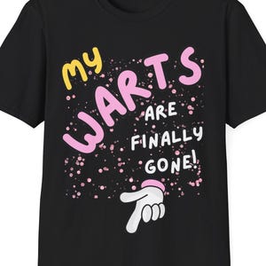May include: Black t-shirt with a pink and yellow graphic that says "My Warts Are Finally Gone!" with a pink hand pointing to the right.