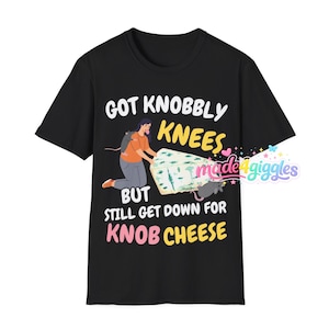 May include: A black short-sleeved t-shirt featuring a graphic of a person kneeling next to a large wedge of blue cheese with two grey rats. The text reads GOT KNOBBLY KNEES BUT STILL GET DOWN FOR KNOB CHEESE. The logo made4giggles is also visible.