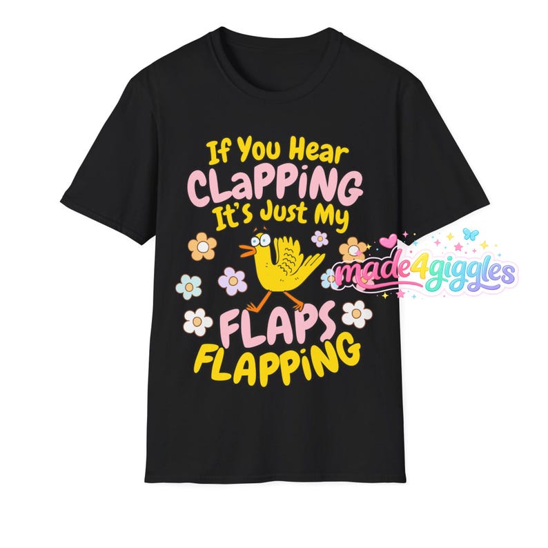Może przedstawiać: Czarny t-shirt z napisem "If You Hear CLAPPING It's Just My FLAPS FLAPPING" w kolorze r&oacute;żowym i ż&oacute;łtym. Ż&oacute;łta kresk&oacute;wkowa kaczka z trzepoczącymi skrzydłami znajduje się na środku, otoczona kwiatami. Koszulka ma okrągły dekolt i kr&oacute;tkie rękawy.