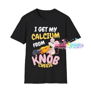 May include: Black t-shirt with a graphic featuring two cartoon mice and a cheese wedge. The text reads "I GET MY CALCIUM FROM KNOB CHEESE" in yellow and pink. The shirt has a crew neck.