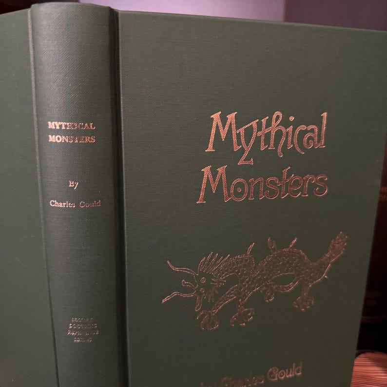 May include: A green hardback book with the title "Mythical Monsters" in gold lettering. The book cover features a gold illustration of a dragon.