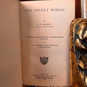 Pu&ograve; includere: La copertina del libro "The Occult World" con il titolo e il nome dell'autore, A.P. Sinnett, stampati in nero su uno sfondo color crema. Il libro &egrave; una sesta edizione americana della quarta edizione inglese con le correzioni dell'autore e una nuova prefazione.