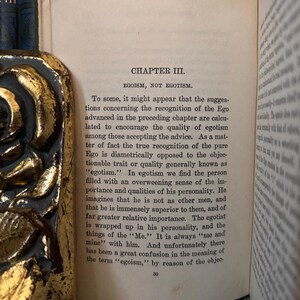 May include: A page from a vintage book titled "Egoism, Not Egotism." The text discusses the difference between egoism and egotism, explaining that true egoism is not about self-importance but rather a recognition of the self.