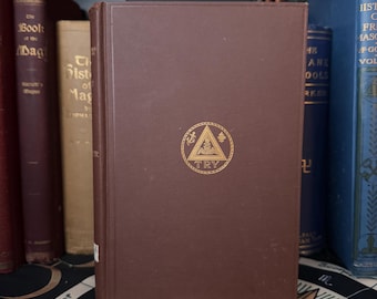 May include: A brown hardcover book with gold lettering and a gold emblem that says "TRY". The book is part of a collection of antique books on a shelf. Other books are visible in the background.