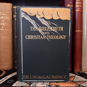 May include: A dark green hardback book with gold lettering on the spine and front cover. The title is "God, The Bible, Truth and Christian Theology" by Dr. L.W. de Laurence.