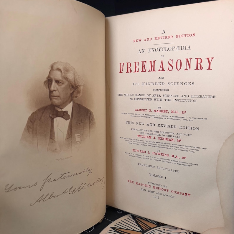 Puede incluir: Libro abierto con un retrato en sepia de un hombre con traje y pajarita. El t&iacute;tulo del libro es "An Encyclop&aelig;dia of Freemasonry". El libro es el Volumen 1, publicado en 1917 por The Masonic History Company.